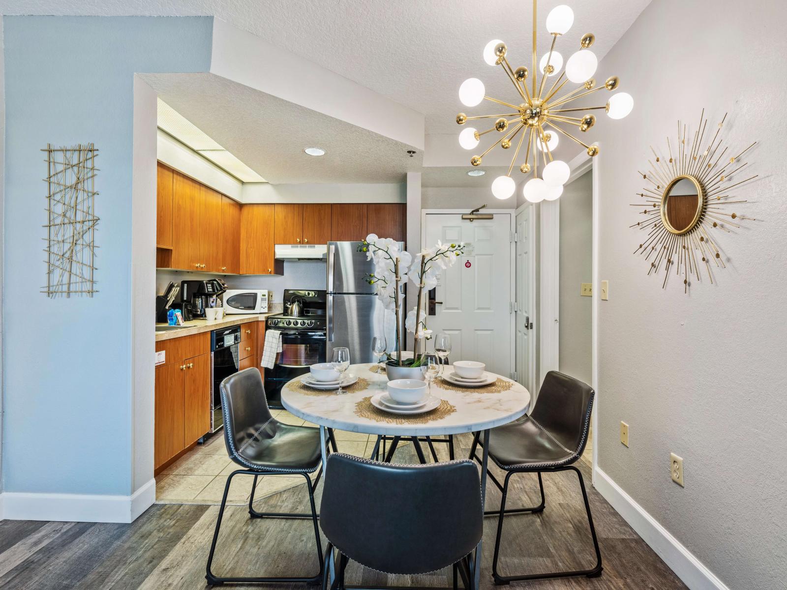 Chic dining area of the condo in Orlando Florida - Dining table for 4 persons - Open-concept design facilitates seamless flow between living, dining, and kitchen - Artfully arranged table settings for a touch of elegance