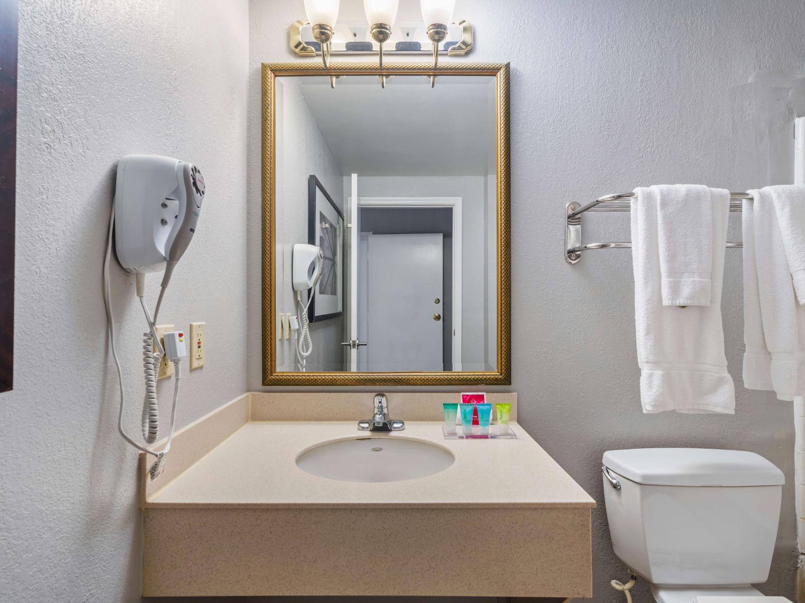 Well-Lit bathroom of the condo in Orlando Florida - Chic vanity with large mirror and upscale lighting - Essentials provided for convenient stay - Clean lines and refined details for a sophisticated look