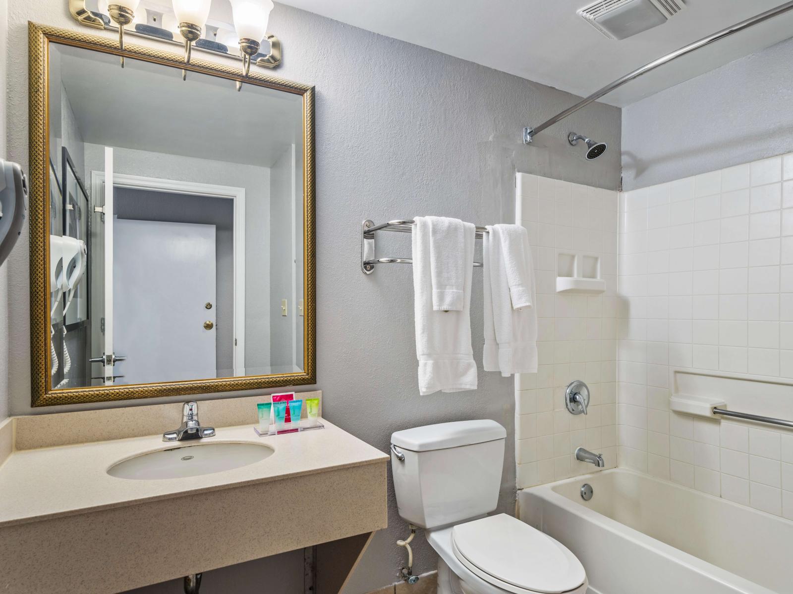 Polished bathroom of the condo in Orlando Florida - Offers bathtub and a shower combo - Bathroom with elegant fixtures and finishes - Large size mirror with upscale lighting