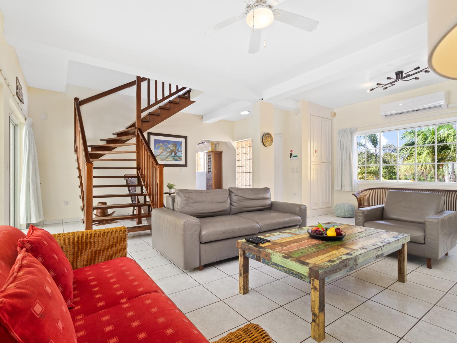 Lush Living Area of the home in Noord Aruba - Stairway to the second floor - A living room that effortlessly combines sophistication, comfort, and functionality - Comfy sofas - Stunning out side views