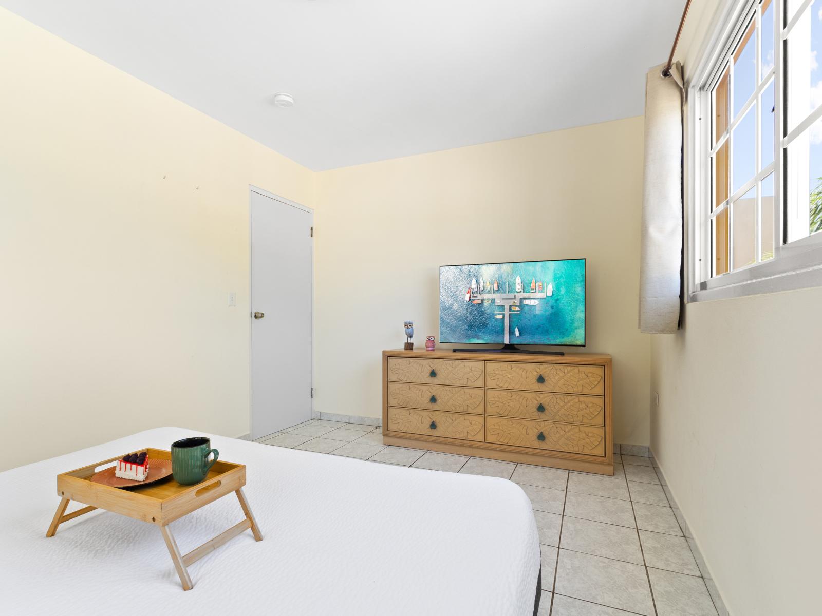 Experience comfort and convenience in our third bedroom, complete with a plush queen bed, smart TV, and ensuite bathroom for a relaxing stay.