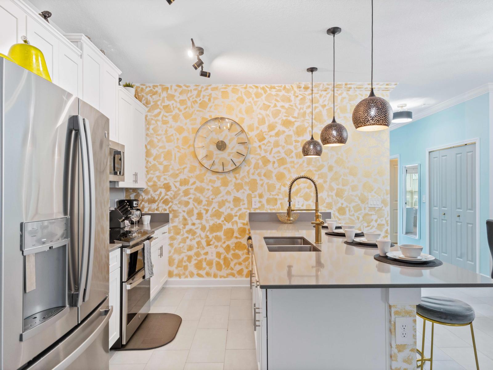 Stylish open concept kitchen with good lighting fronting a countertop table with chairs