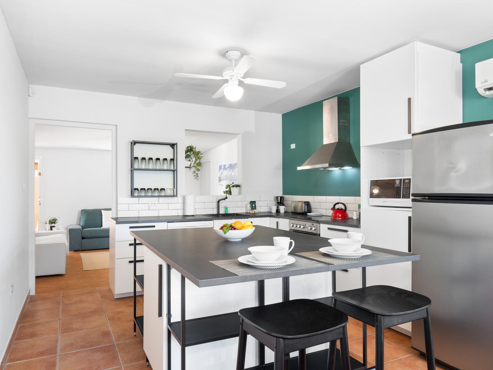 Modern Kitchen of the 3BR House in Noord Aruba - Kitchen Island - Modern kitchen with sleek, stainless steel appliances - High chairs - Smart use of space with versatile storage solutions