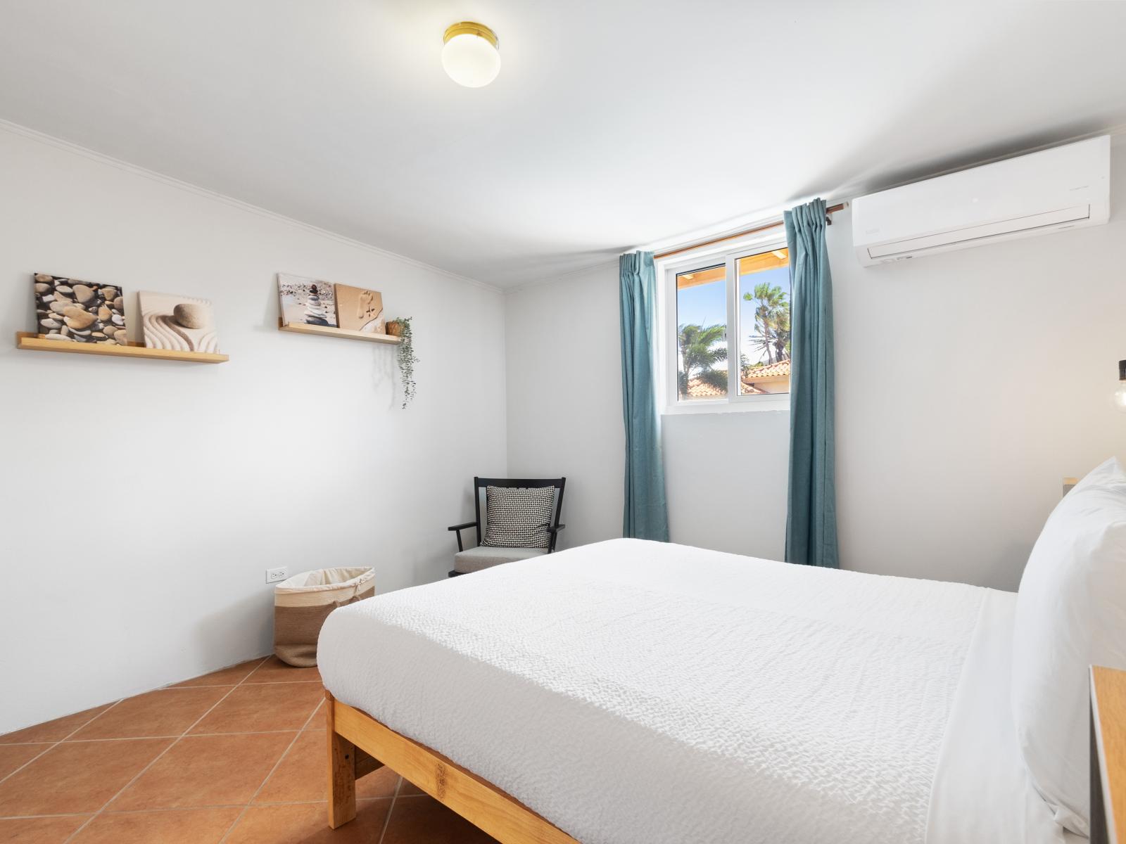 Swish Bedroom of the 3BR House in Noord Aruba - Minimalist decor, creating a clean and uncluttered sleeping space - Elegant Table Lamps - Luxurious bedding for a restful night's sleep