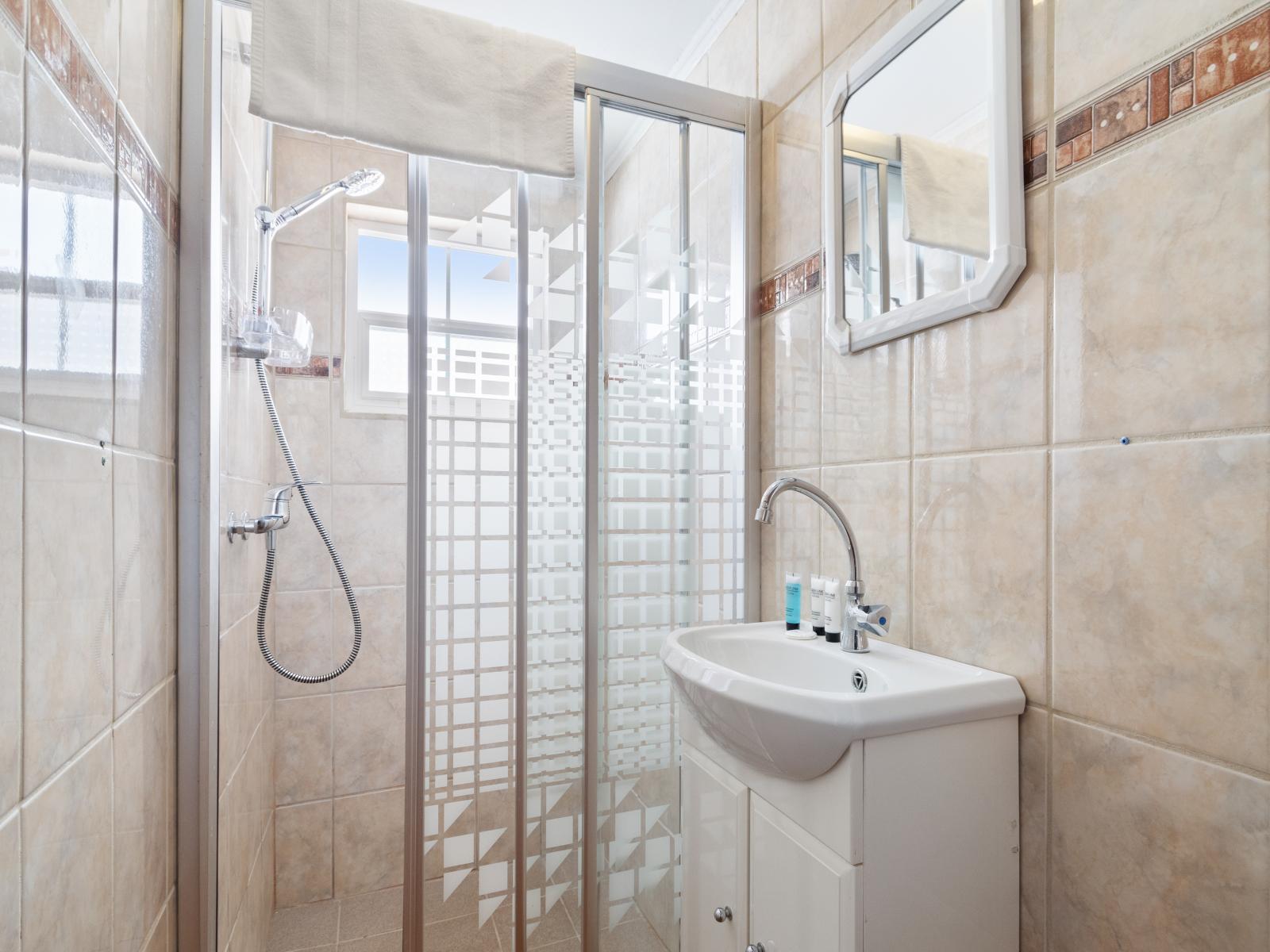 Deluxe Bathroom of the 3BR House in Noord Aruba - Chic design featuring a sleek vanity - Seamless design featuring a glass-enclosed shower - Spacious layout offering a sense of luxury and comfort