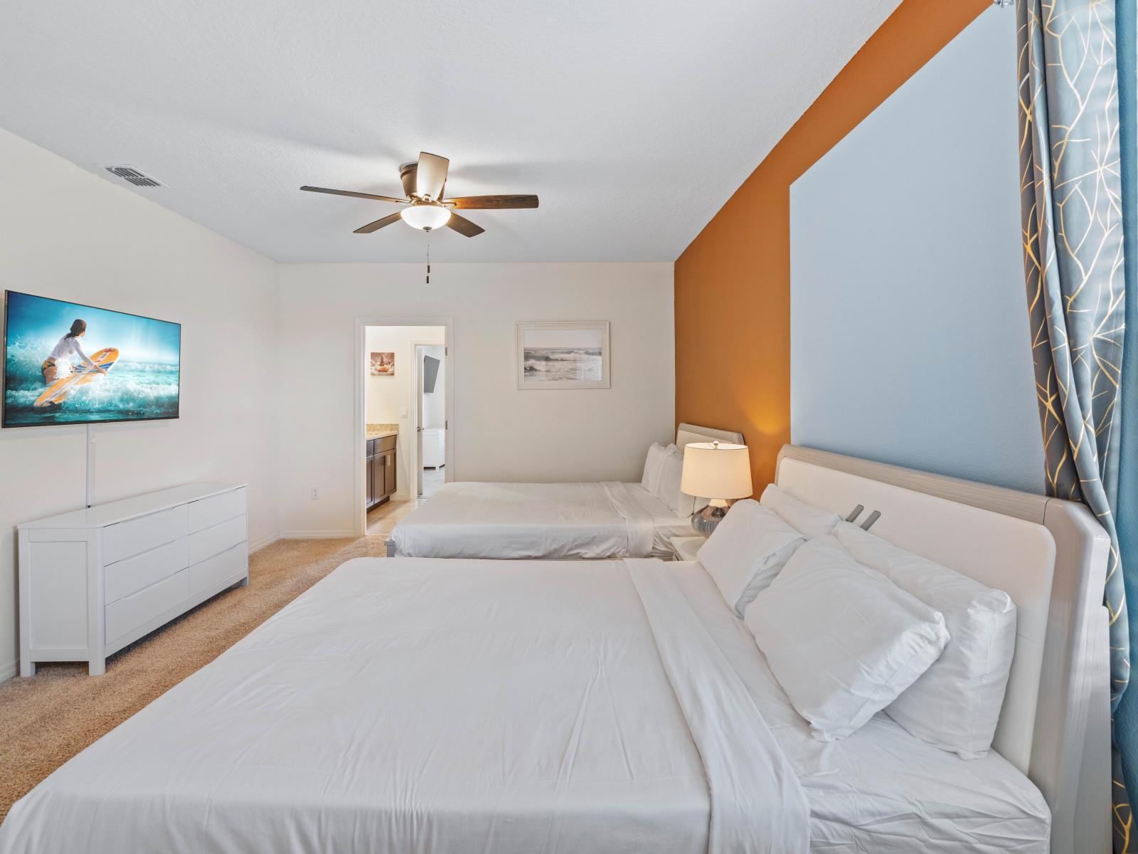 Enjoy the spacious comfort of Bedroom 4, featuring two double beds and a private bathroom for your relaxation.