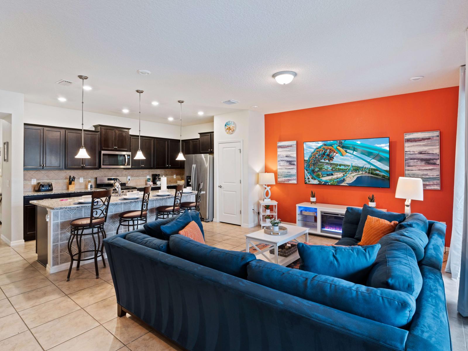 Discover a colorful haven in our living room, designed for playfulness and relaxation. With ample seating for watching shows, movies, games, and more, it's the perfect gateway to easy pool access for added enjoyment.