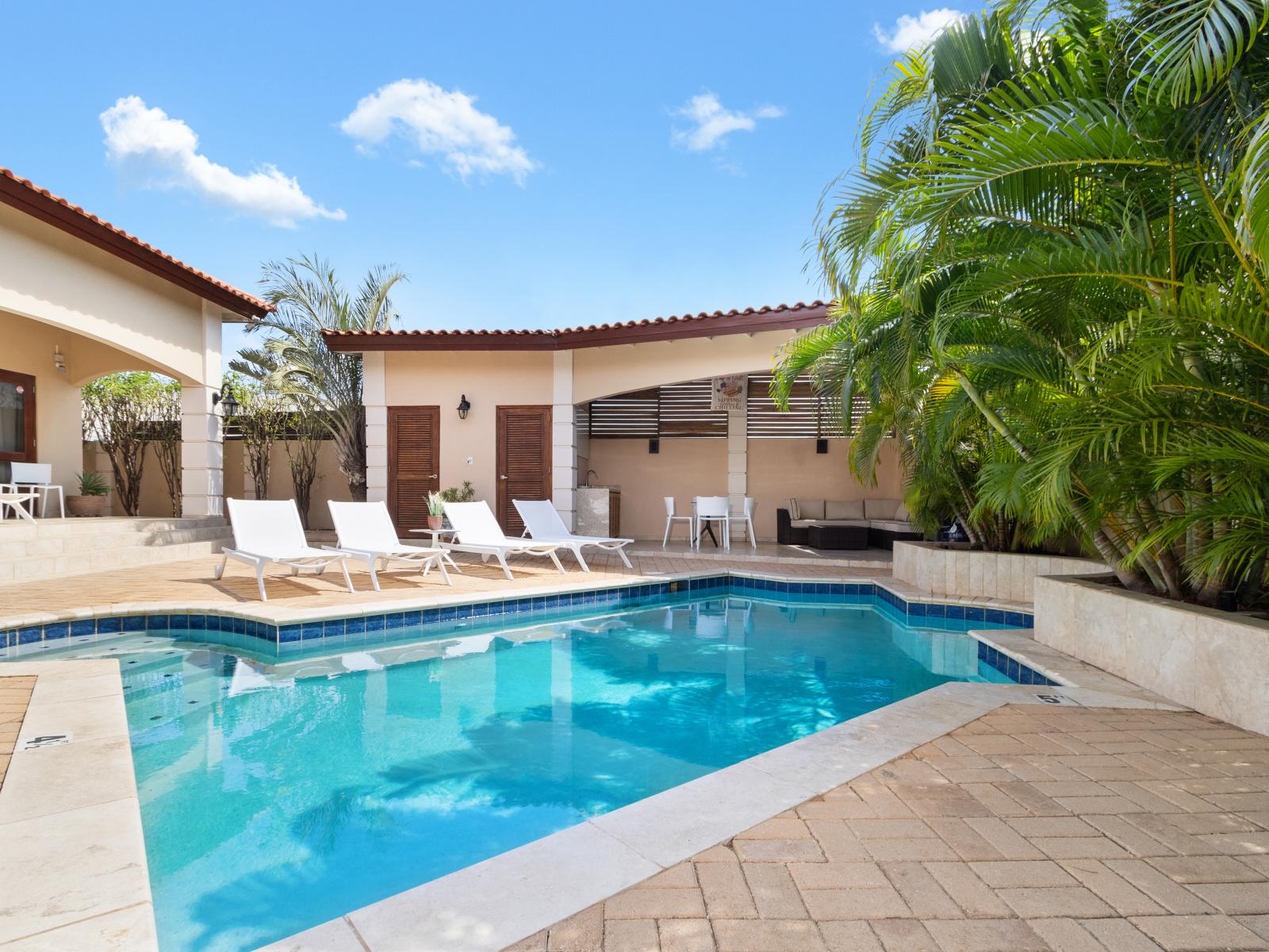 Enjoy the private pool alongside covered outdoor seating areas, ideal for relaxing and entertaining in comfort.
