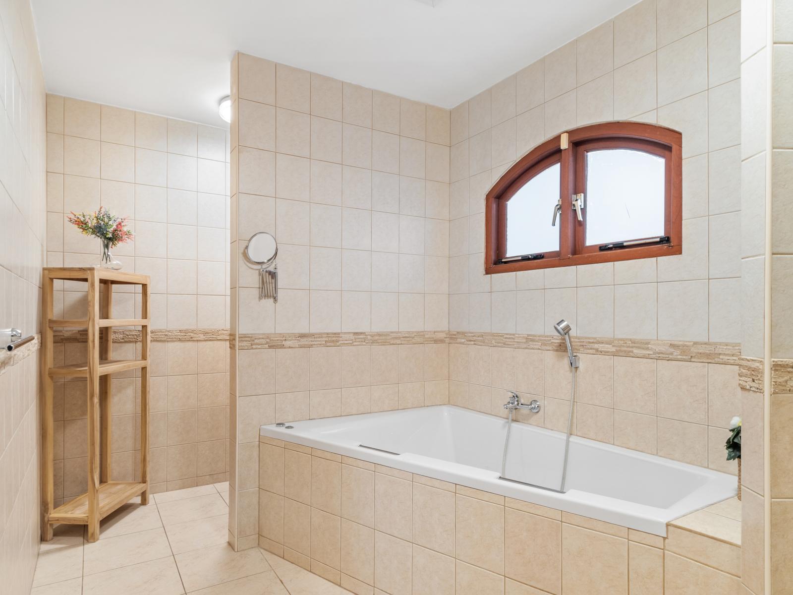 Bathroom 1 features a jetted tub, walk-in shower, and double vanity for added comfort and convenience.