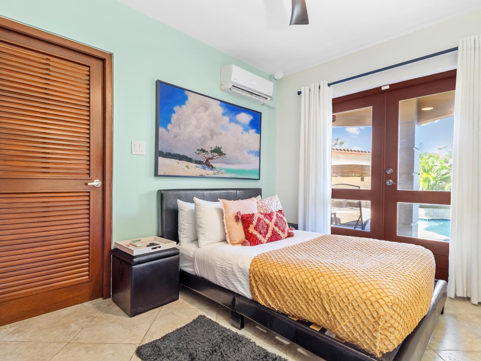 Bedroom 2 features a queen-size bed and direct access to the pool area for added convenience and enjoyment.
