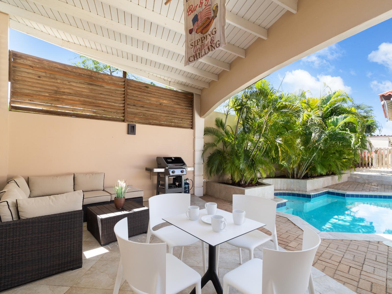 Lounge area next to the pool with your own grill