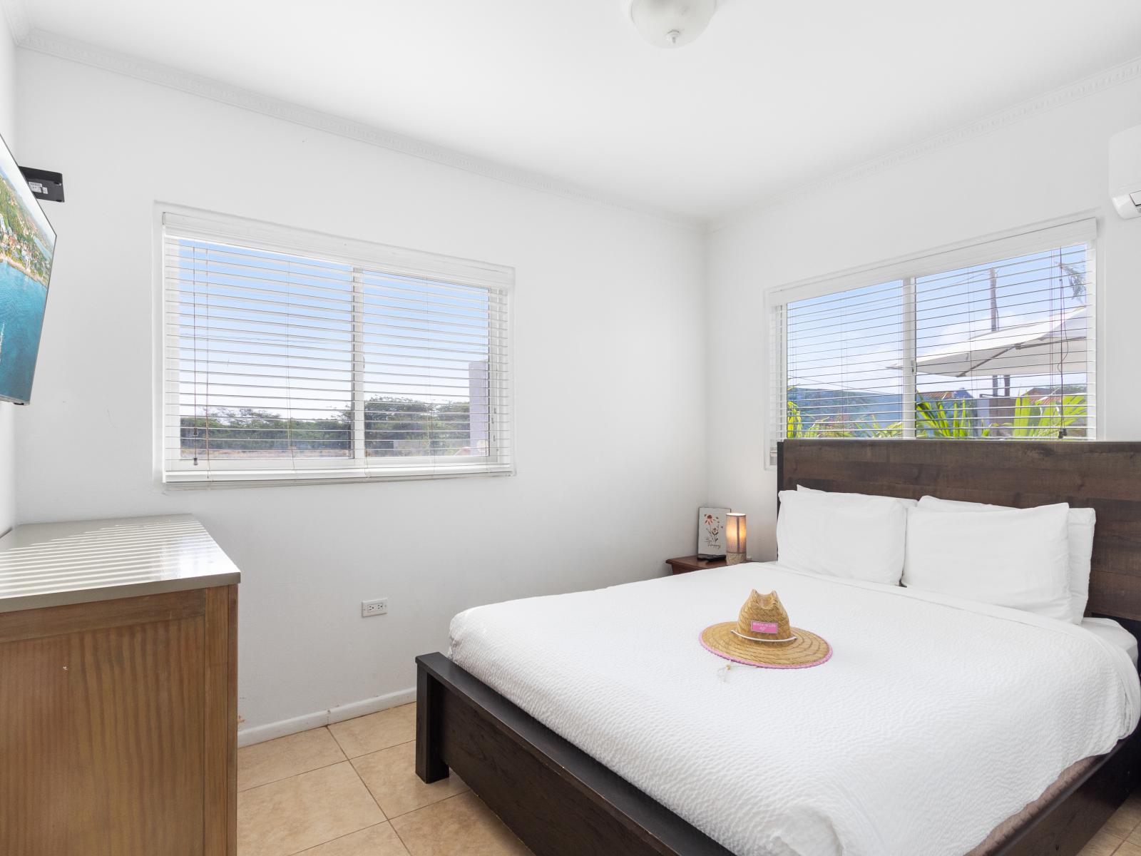 Distinguished bedroom of the 2BR condo in Noord Aruba - Smart TV and Netflix - Cozy retreat with a plush bed, perfect for relaxation - EnSite bathroom for privacy and convenience