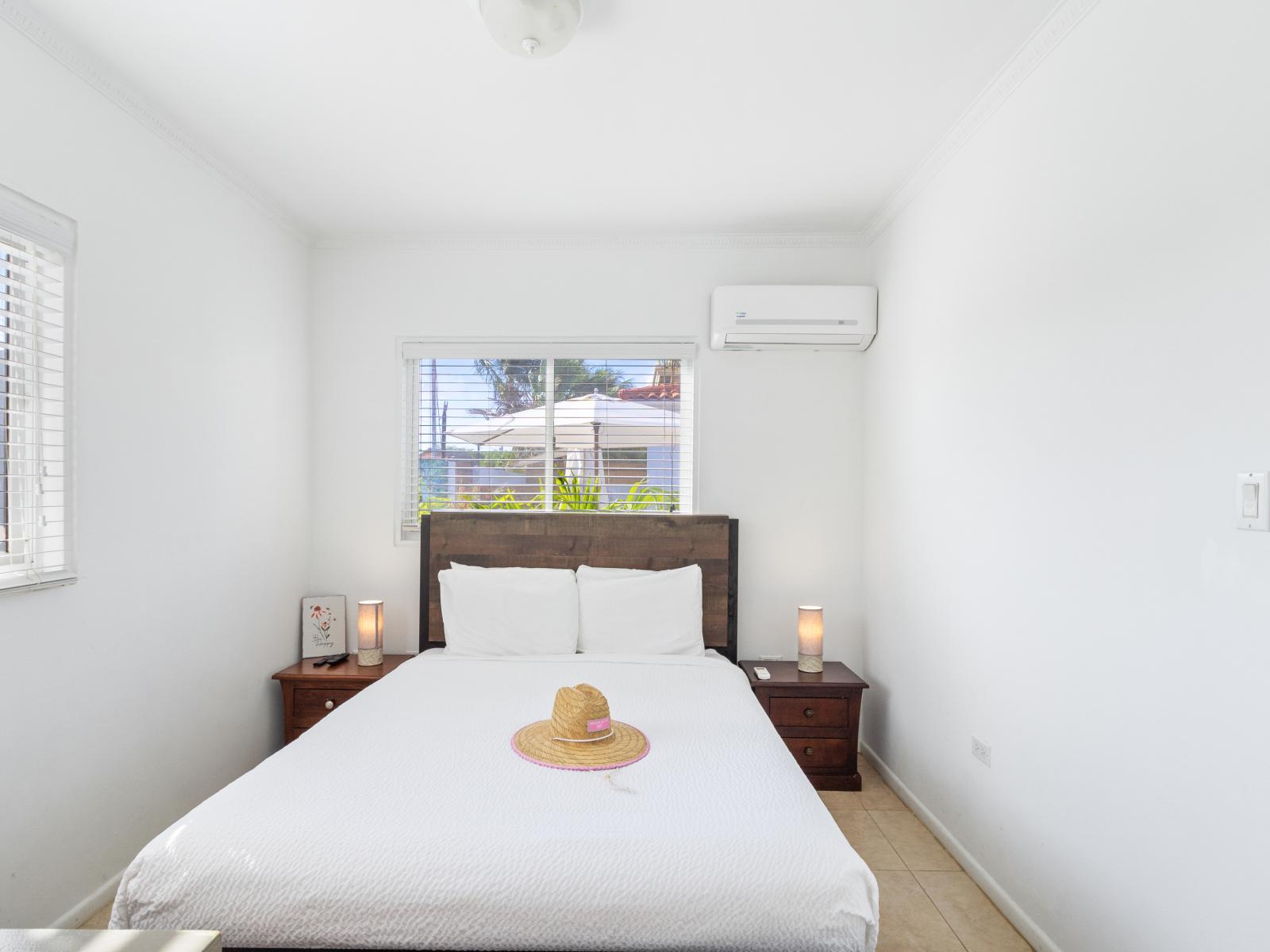 Swish Bedroom of the 2BR condo in Noord Aruba - Minimalist decor, creating a clean and uncluttered sleeping space - Smart TV and Netflix - Luxurious bedding for a restful night's sleep - Ensuite Bathroom