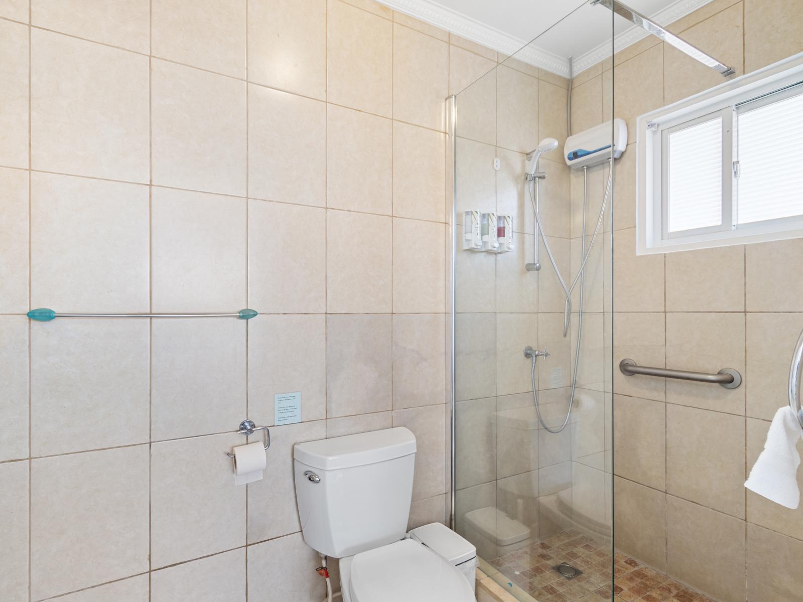 Pompous Bathroom of the 2BR condo in Noord Aruba - Sophisticated color palette creating a serene ambiance - Contemporary fixtures for a touch of indulgence - Glass enclosed Shower Area