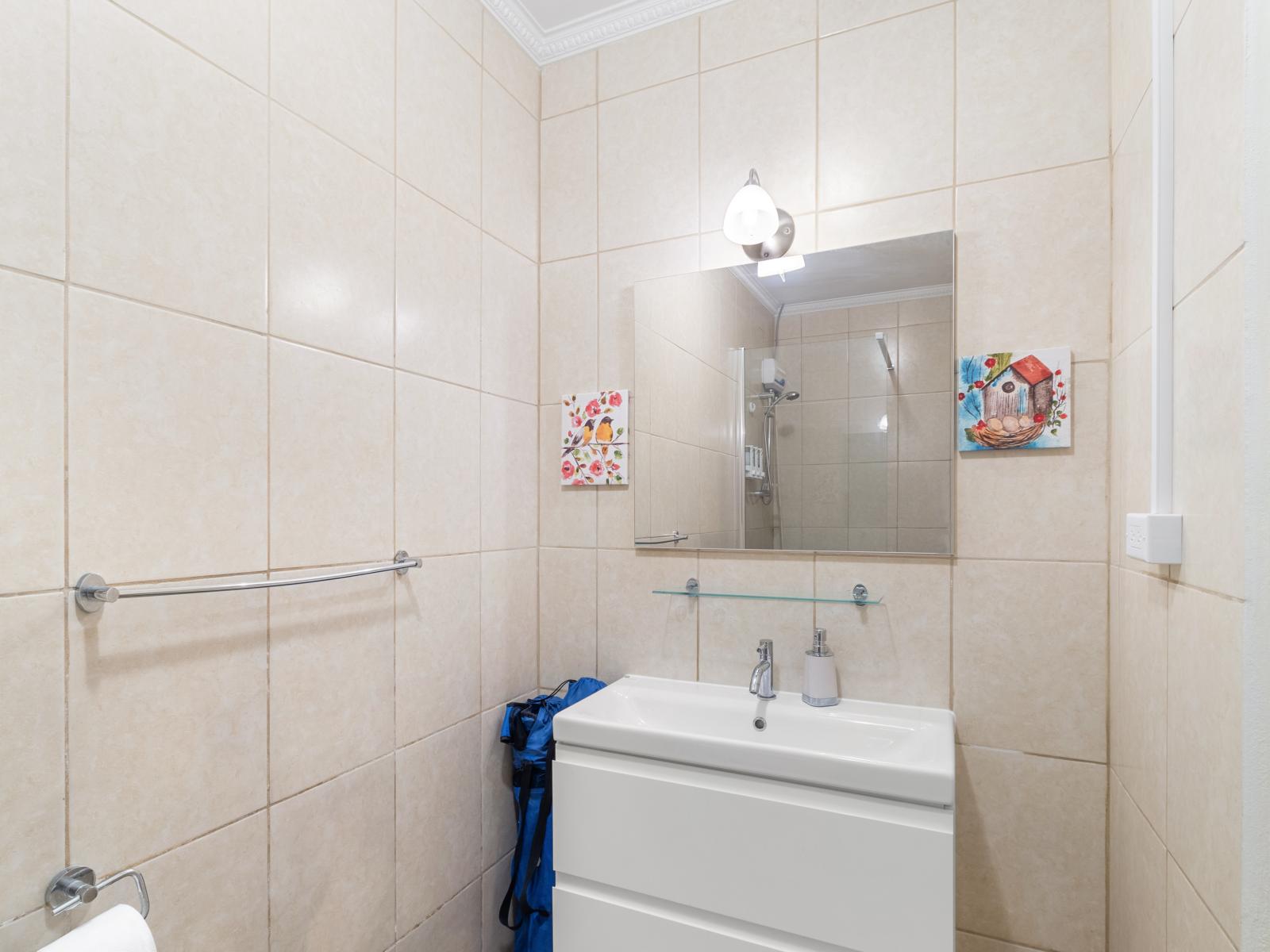 Opulent Tiled Bathroom of 2BR condo Noord Aruba - Neat and Clean Toilet seat - Elegant lighting - Fantastic Vanity with large size wall mirror - Smart use of space