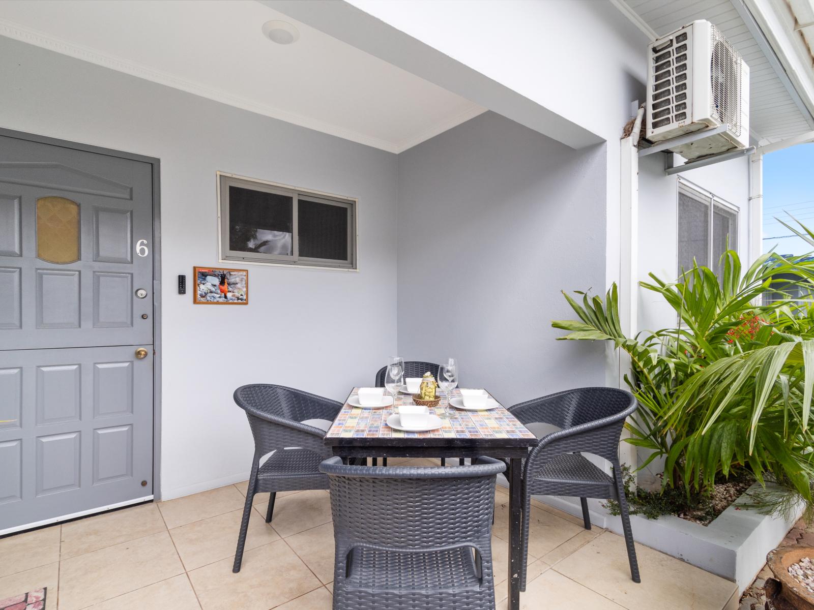 Outdoor private patio dining area of the 2BR condo in Noord Aruba - Embrace a relaxed atmosphere in the great outdoors - Attractive patio furniture and decor - Lush Greenery and refreshing atmosphere