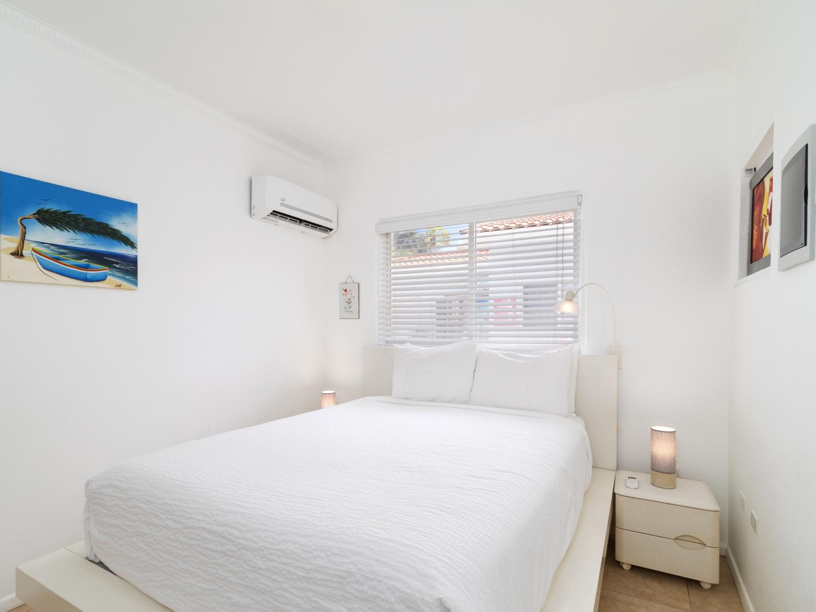 Sink into relaxation in our bedroom, boasting a comfortable queen bed and a wall-mounted flat-screen smart TV, offering the perfect blend of comfort and entertainment for a restful stay.