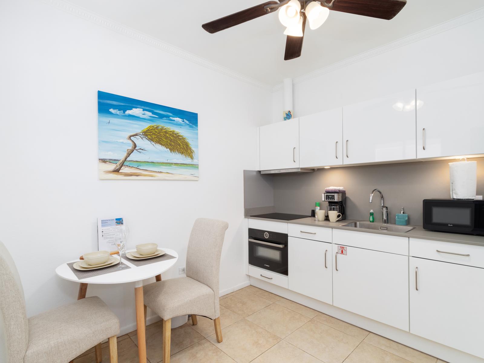 Dining and Kitchen Area of the Apartment in Noord Aruba - 3 Persons Dining - Thoughtful lighting fixtures creating an intimate and inviting atmosphere - Functional and aesthetically pleasing area