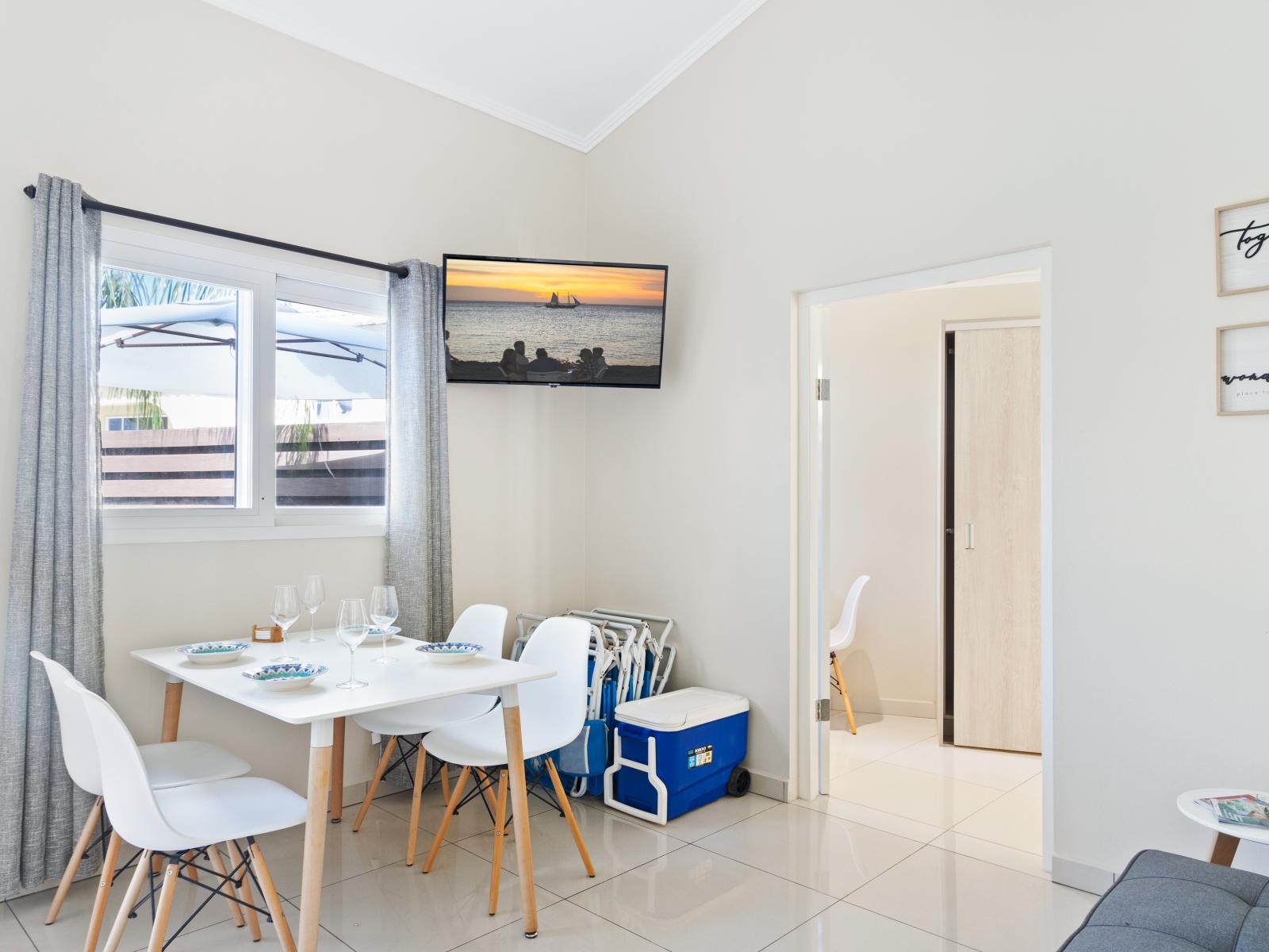 Ornamental Dining Area of the Apartment in Noord Aruba - 4 Persons Dining - Thoughtful lighting fixtures creating an intimate and inviting atmosphere - Smart TV and Netflix - Artfully arranged table settings for a touch of elegance