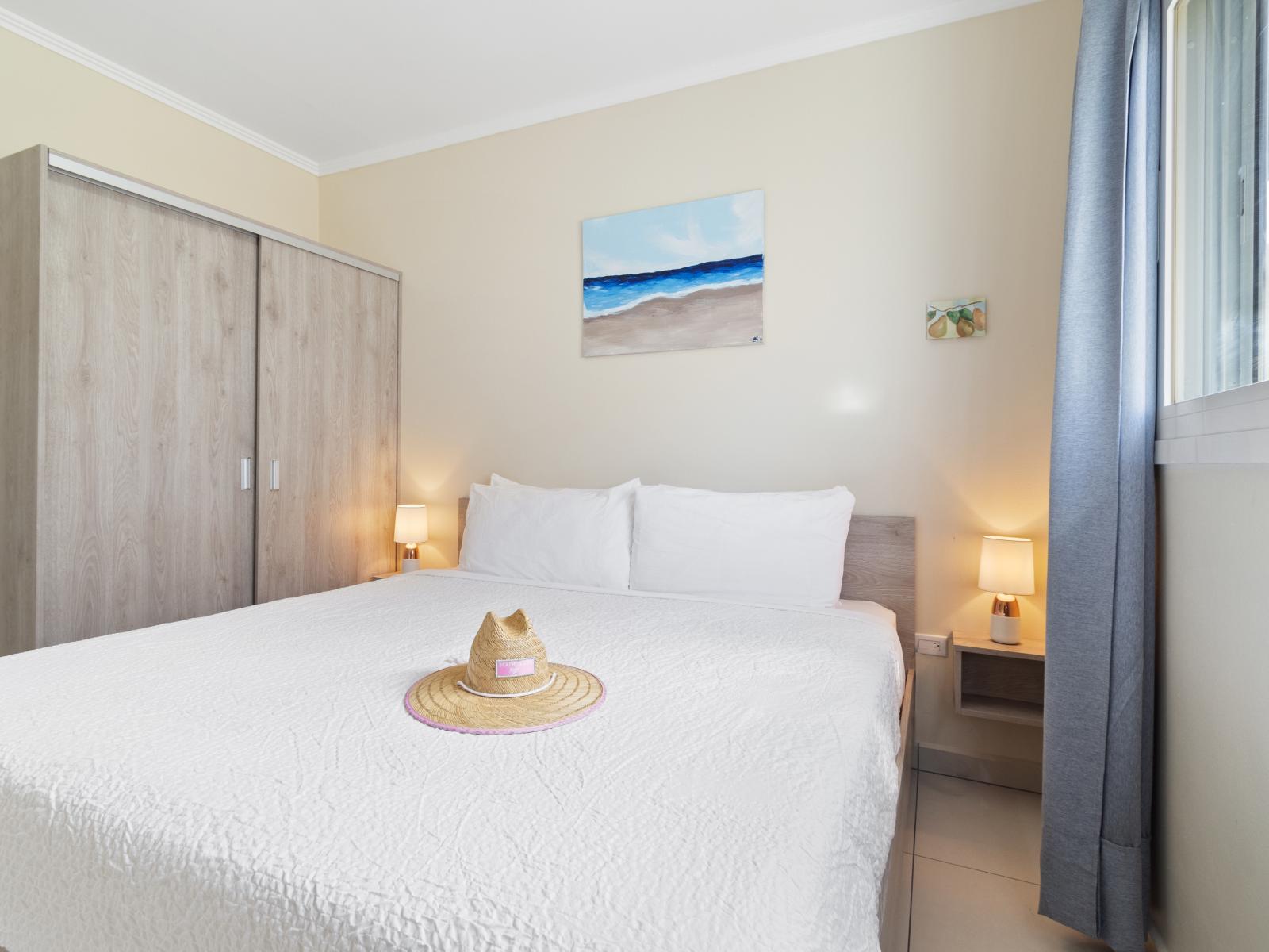 Lofty Bedroom of the Apartment in Nrood Aruba - Cozy retreat with a plush bed, perfect for relaxation - Bright and airy bedroom with large windows for natural illumination - Modern and stylish decor that complements the space