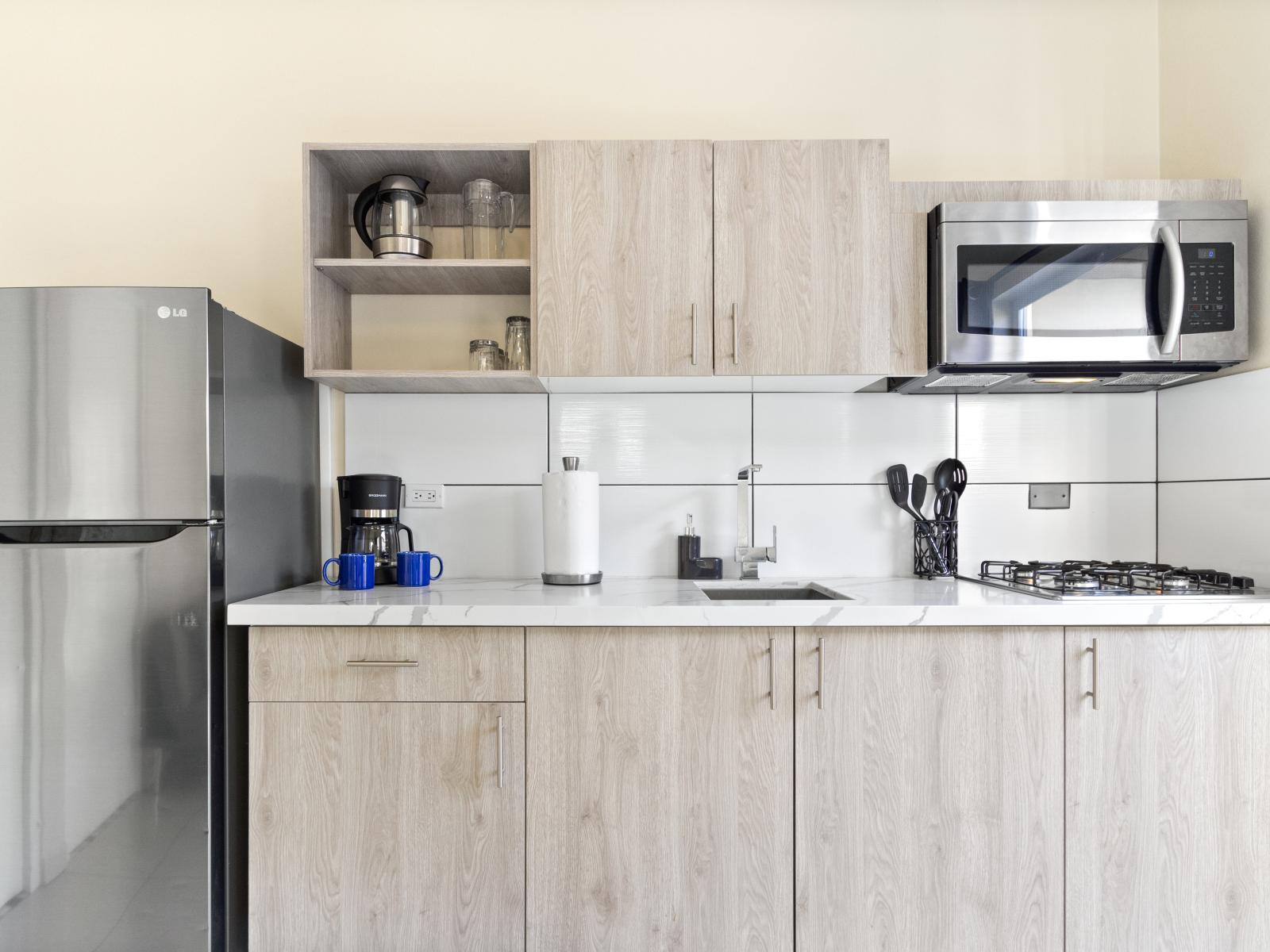 Modern Kitchen of the Apartment in Noord Aruba - Well-lit space with strategically placed task lighting - Elegant and coordinated color palette for a cohesive look - Fully Equipped