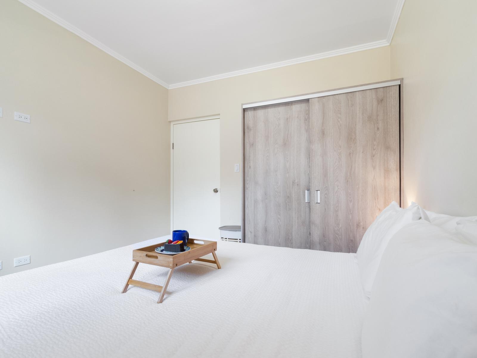 Deluxe Bedroom of the Apartment in Noord Aruba - Full King Size Bed - Minimalist decor, creating a clean and uncluttered sleeping space - Cozy retreat with a plush bed, perfect for relaxation - Smart TV and Netflix - Full size wardrobe