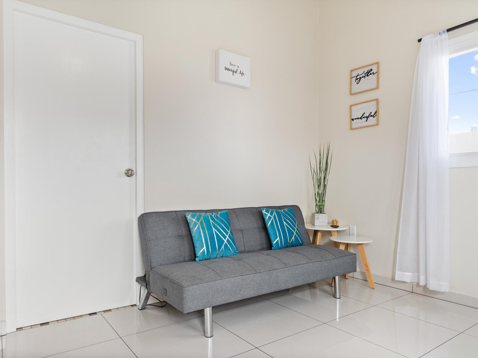 Exclusive living area of the apartment in Noord, Aruba - Cosy sofas - Beautifully located windows of the apartment with outside views - Beautifully decored with wall paintings - Availability of TV and Netflix
