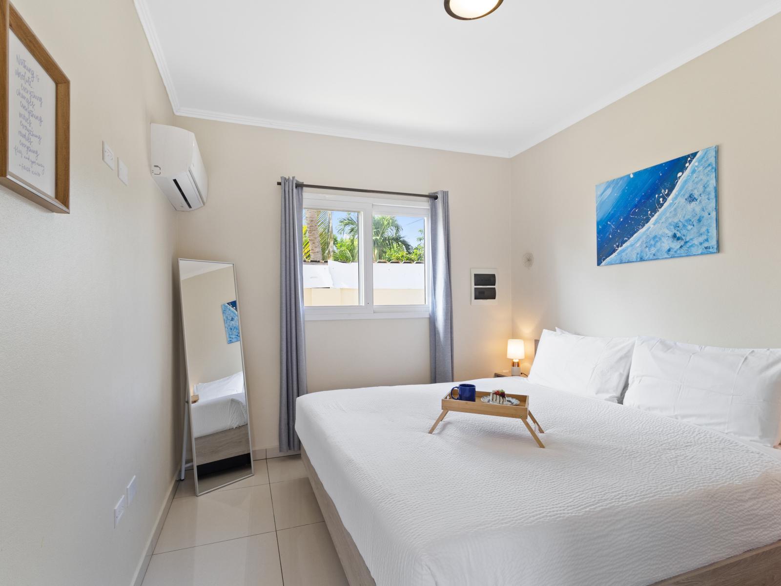 Exquisite bedroom of the apartment in Noord, Aruba - Comfy king size bed - Elegantly designed room beautifully decored with large aesthetic wall paintings - Majestic table lamps - Neat and clean linen with soft pillows - Large size stand mirror