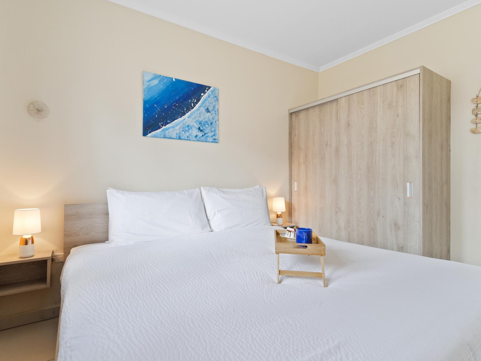 Exclusive bedroom of the apartment in Noord, Aruba - Comfy king size bed - Elegantly designed room beautifully decored with large aesthetic wall paintings - Majestic table lamps - Neat and clean linen with soft pillows - Large size stand mirror