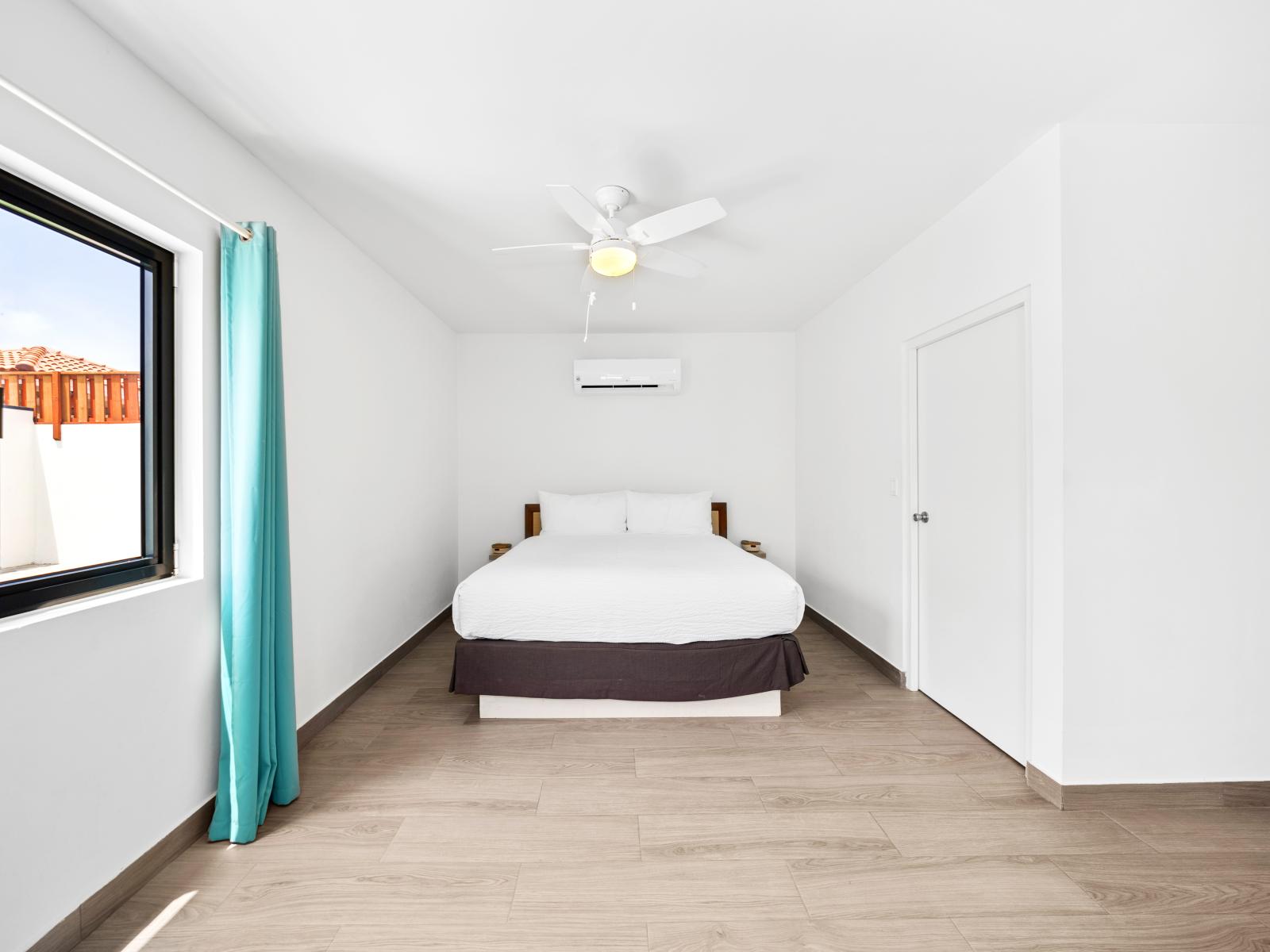 Relax in the comfort of the master bedroom of home in Noord, Aruba - Spacious double bed with soft pillows and high-quality linens. - Sophisticated lighting fixtures that enhance the room's ambiance.