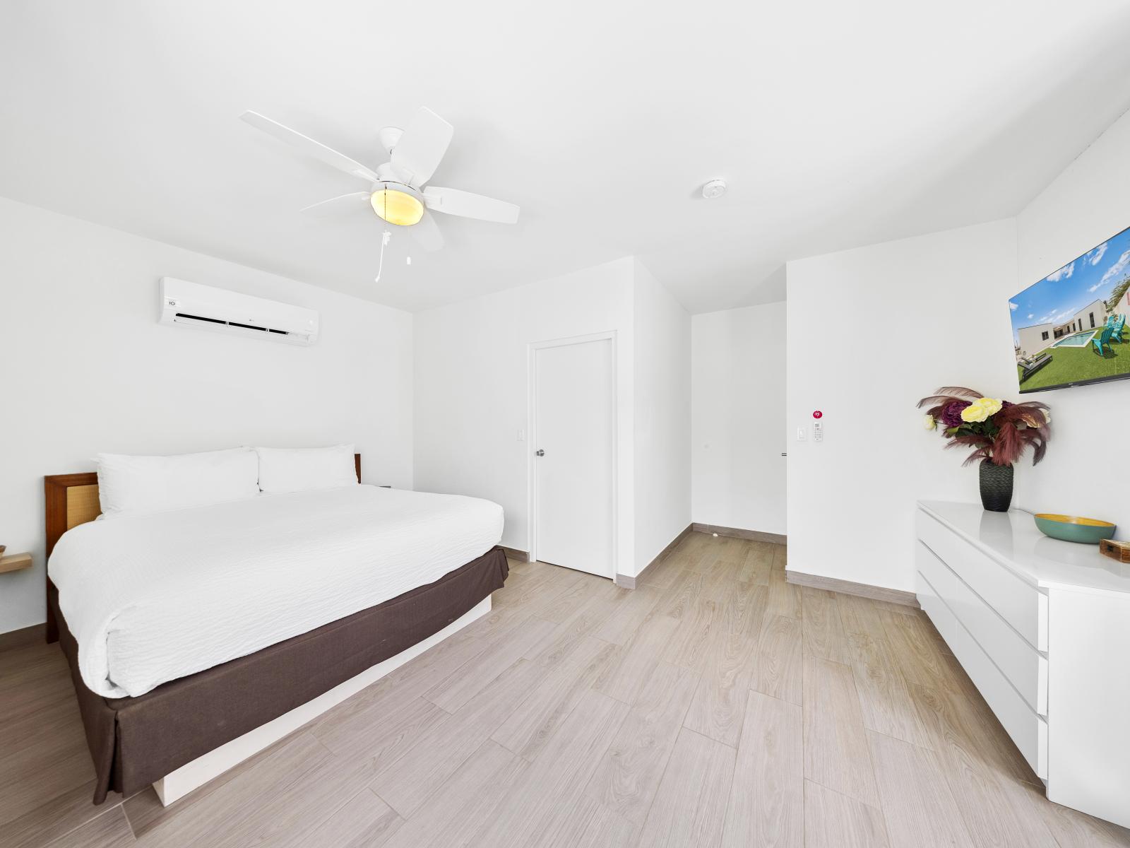 Warm and inviting bedroom of the home in Noord, Aruba - Featuring a cozy double bed - Enjoy your favorite shows and movies on a wall-mounted smart TV. - Spotlessly clean and well-maintained for your comfort.