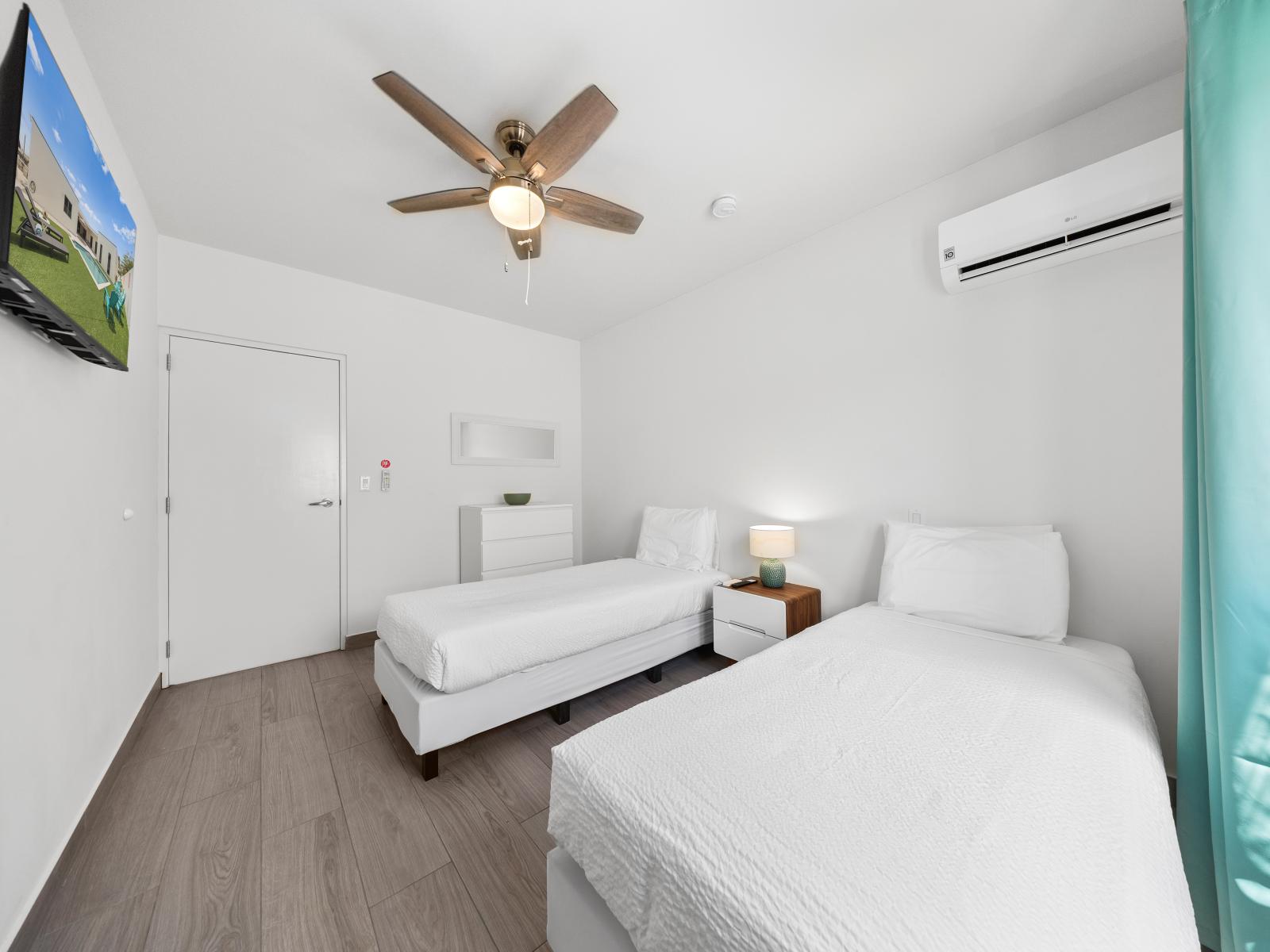 Discover your own private sanctuary in bedroom of the home in Noord, Aruba. - With cozy twin single beds it offers ample room to relax and recharge. - Enjoy movies and TV shows on wall mounted flat screen smart TV.