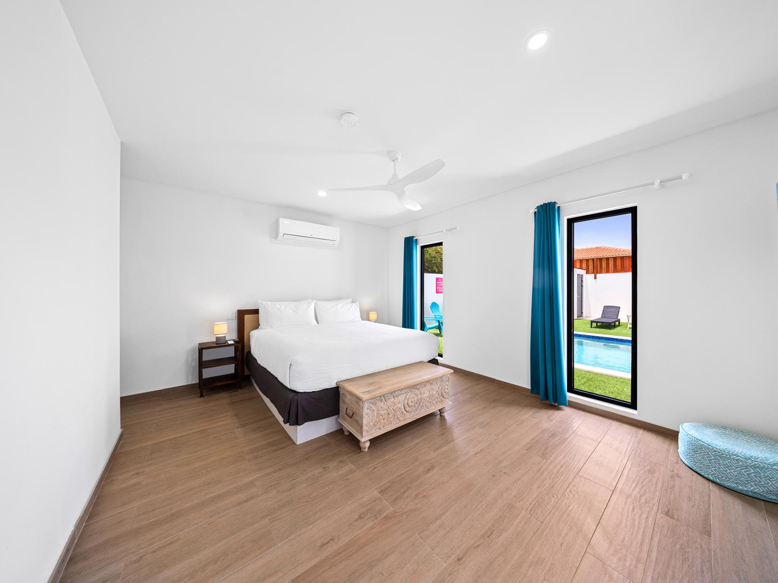 Welcome to your peaceful bedroom of the home in Noord, Aruba - Stunningly wooden furnished floor - A comfy double bed for restful night sleep - Bright windows with backyard and pool views