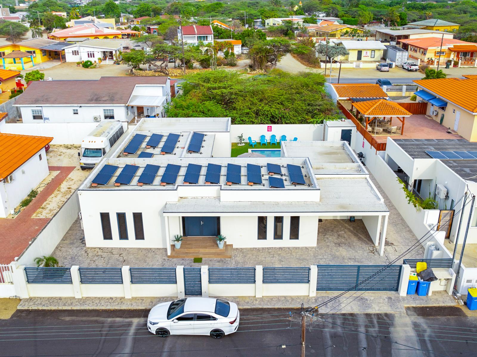 - Greet by a charming front entrance framed by vibrant flora in Noord, Aruba - The front of the home exudes a sense of warmth and hospitality, promising a memorable stay from the moment you arrive.