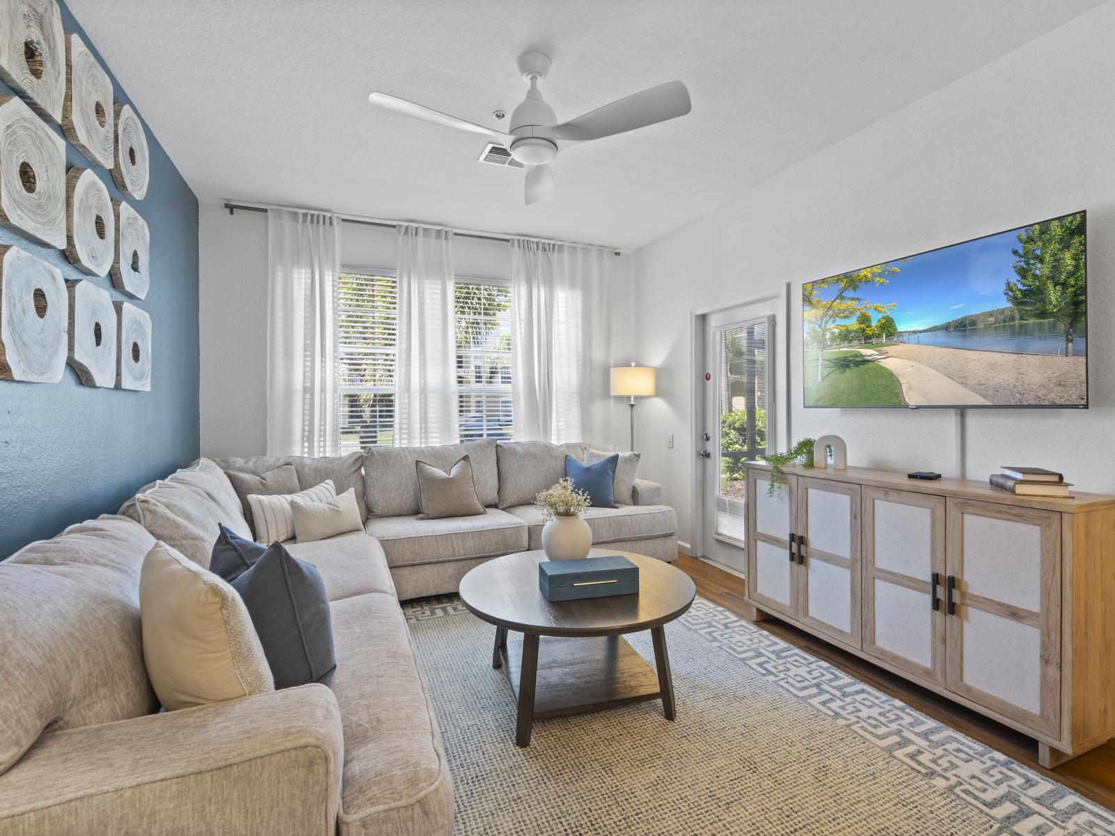 Modern living room of the condo in Kissimmee, Florida - Cozy couches for relaxation - Thoughtfully arranged furniture blending comfort with elegance - Carefully selected lighting fixtures, balancing practicality with charm - Smart TV with Netflix