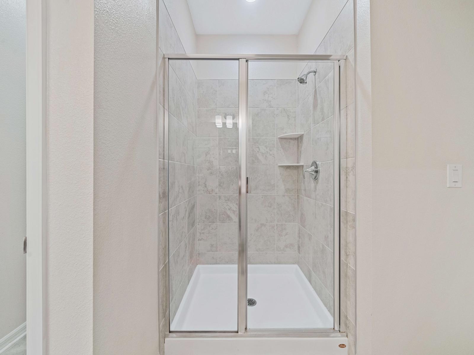 Comfortable Bathroom of the apartment in Kissimmee - Beautiful Vanity with large size wall mirror - Sufficient storage space - Neat and clean toilet seat - Availability of all bathroom amenities - Stunning glass cabin shower area