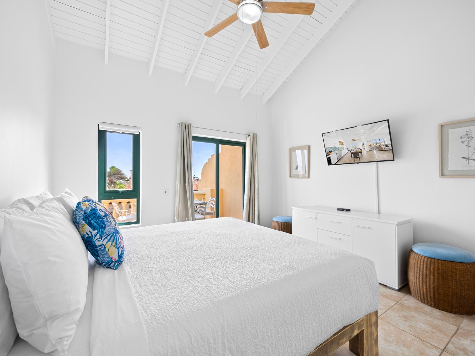 Bright bedroom of the condo in Noord Aruba - Features a king size bed for restful nights - Balcony access with seating for outdoor moments - Smart TV for endless entertainment