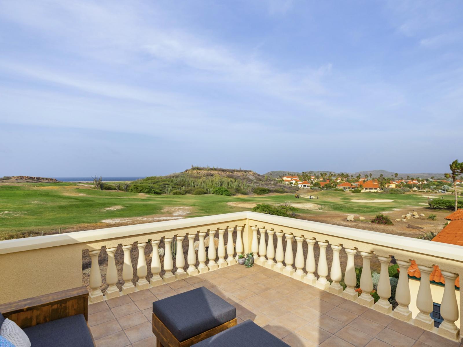 Refreshing private balcony of the condo in Noord Aruba - Golf course and ocean view from the balcony - Spacious balcony extends living space for outdoor enjoyment - Plush seating arrangements