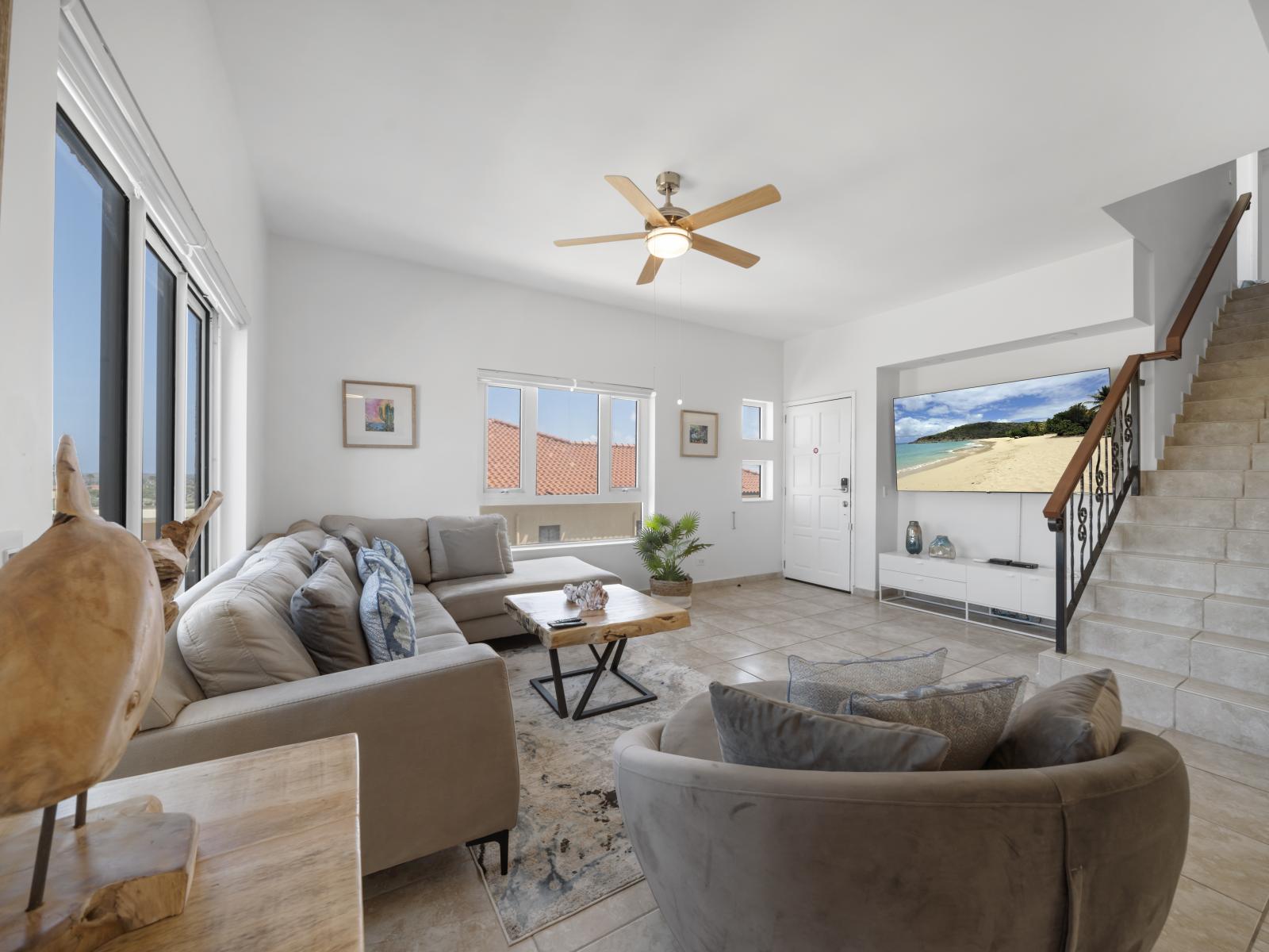 Alluring living area of the condo in Noord Aruba - With wall mounted flat large screen smart TV for movie nights - Elegantly decorated space with a neutral color palette for a timeless appeal - Plush sofas to relax and recharge