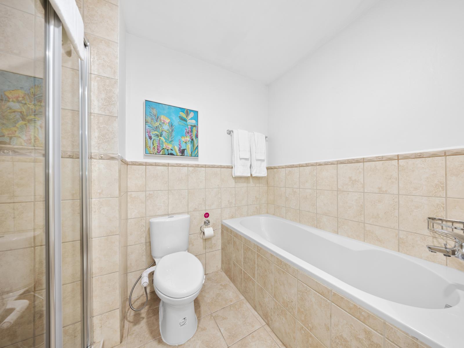 Polished bathroom of the condo in Noord Aruba - Sophisticated color palette creating a serene ambiance - Inviting bathroom with a soothing color palette for a tranquil feel - Superb bathtub