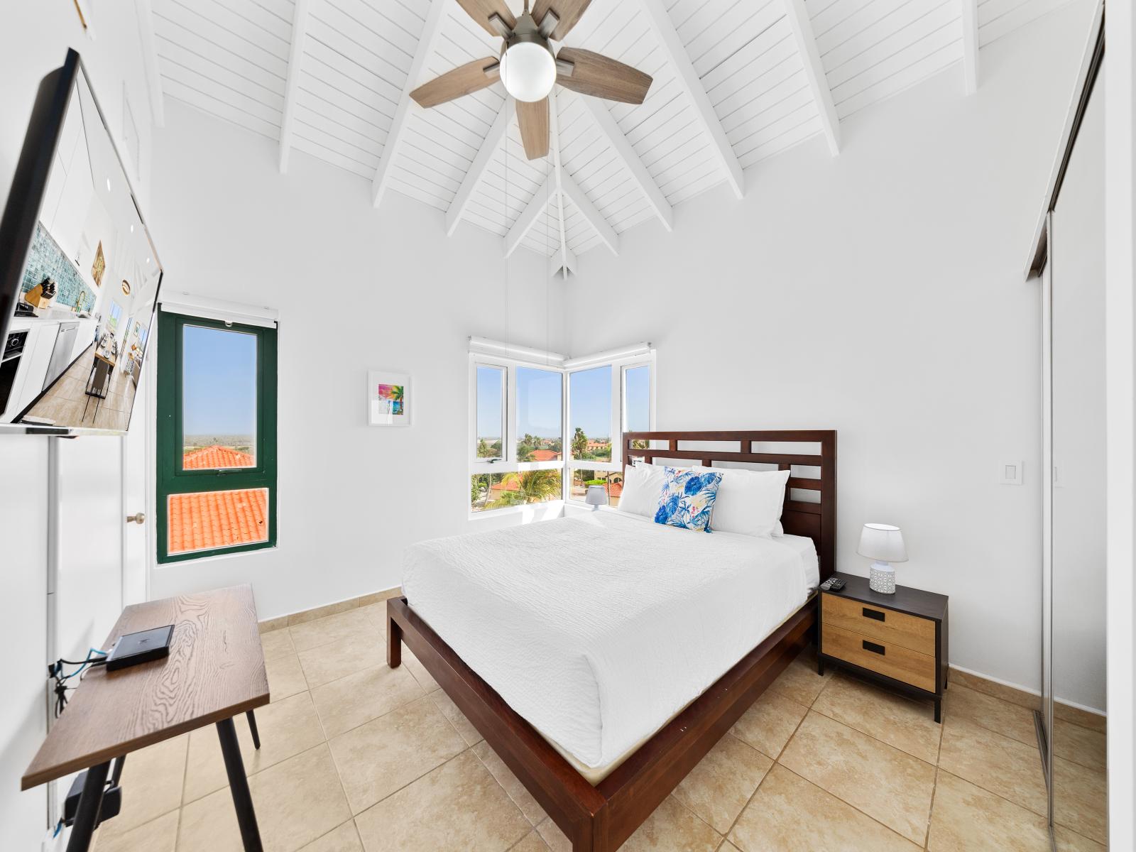 Enchanting bedroom of the condo in Noord Aruba - Features a queen size bed for comfortable nights - Spacious bedroom offering comfort and style - Minimalist decor, creating a clean and uncluttered sleeping space