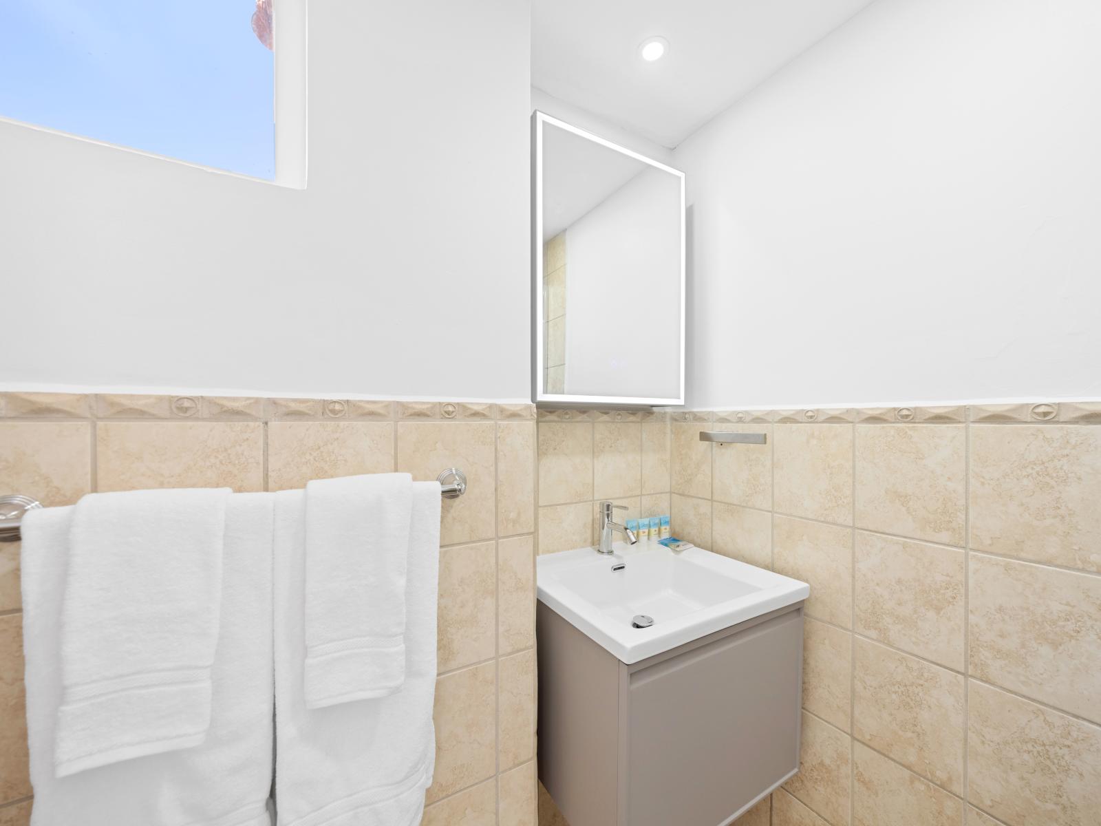 Elegant bathroom of the condo in Noord Aruba - Contemporary fixtures for a touch of indulgence - Inviting bathroom with a soothing color palette for a tranquil feel - Harmonious blend of classic and contemporary elements - Walk-in shower stall