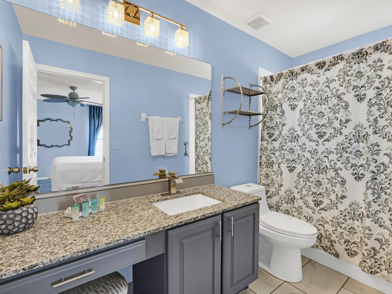 Lavish Bathroom of the Home in Kissimmee Florida - Chic design featuring a sleek vanity and upscale lighting - Polished Vanity with Large Mirror - Bathtub with sliding curtains