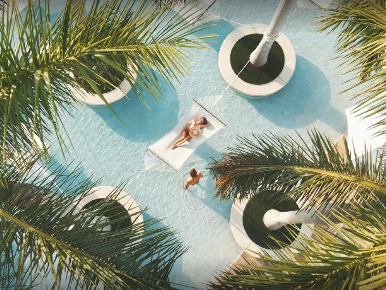 Swing into Serenity: Relax beneath the swaying palms in our Hammocks at Four Seasons Hotel Miami.