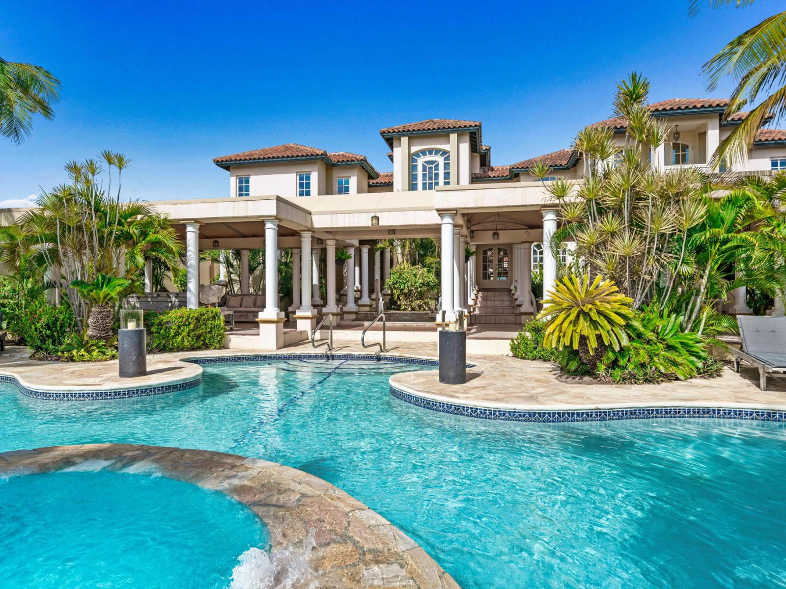 - Mediterranean-style villa surrounded by lush tropical landscaping, featuring an elegant pool for ultimate relaxation - Elegant outdoor space with classical columns and shaded lounge areas - Ideal retreat blending comfort, and serene natural beauty