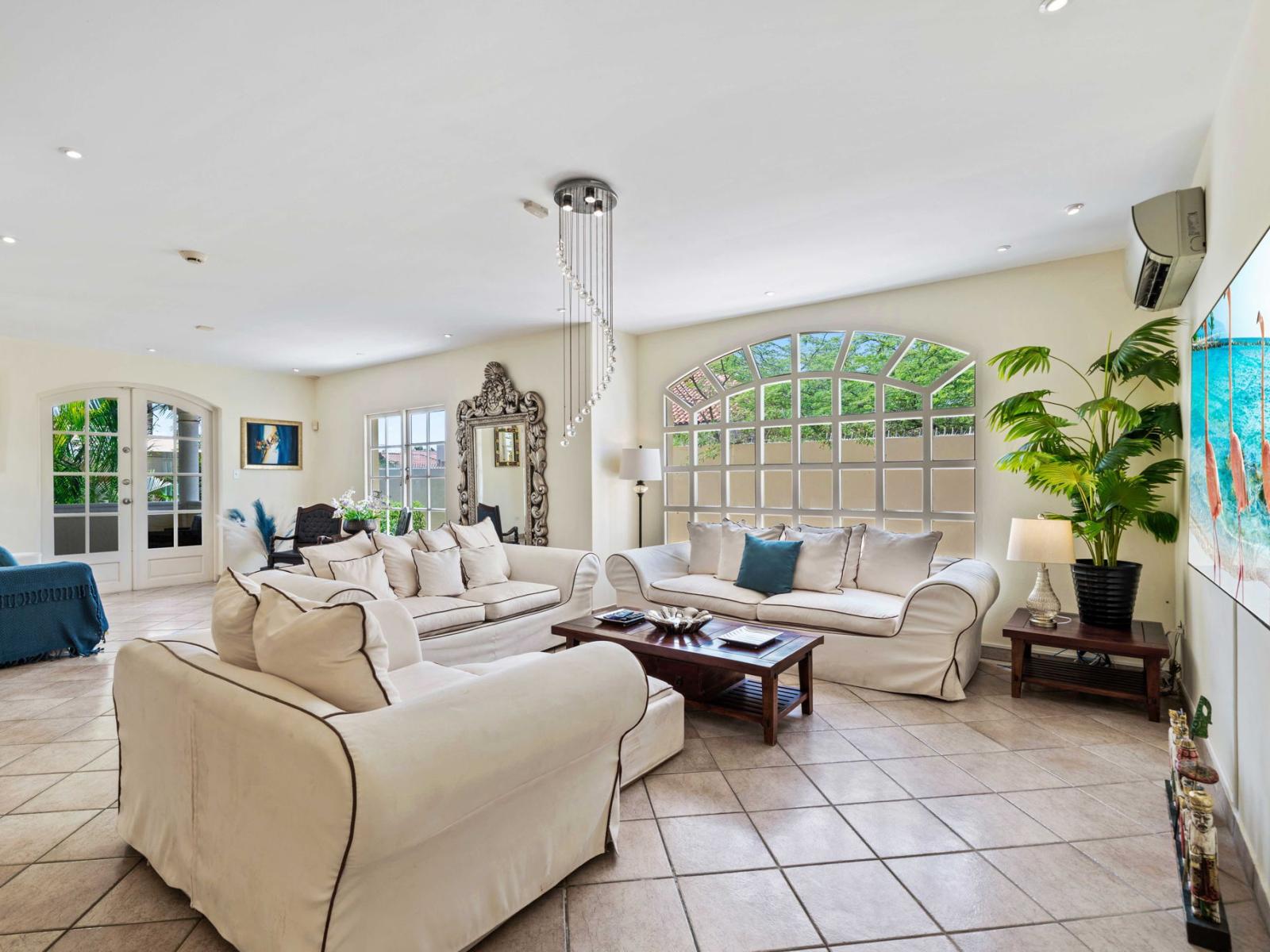 - Spacious living room featuring a smart TV, comfortable seating, and elegant décor - Large windows flood the room with natural light, creating a bright and airy atmosphere - A perfect blend of style and comfort for relaxation or entertainment