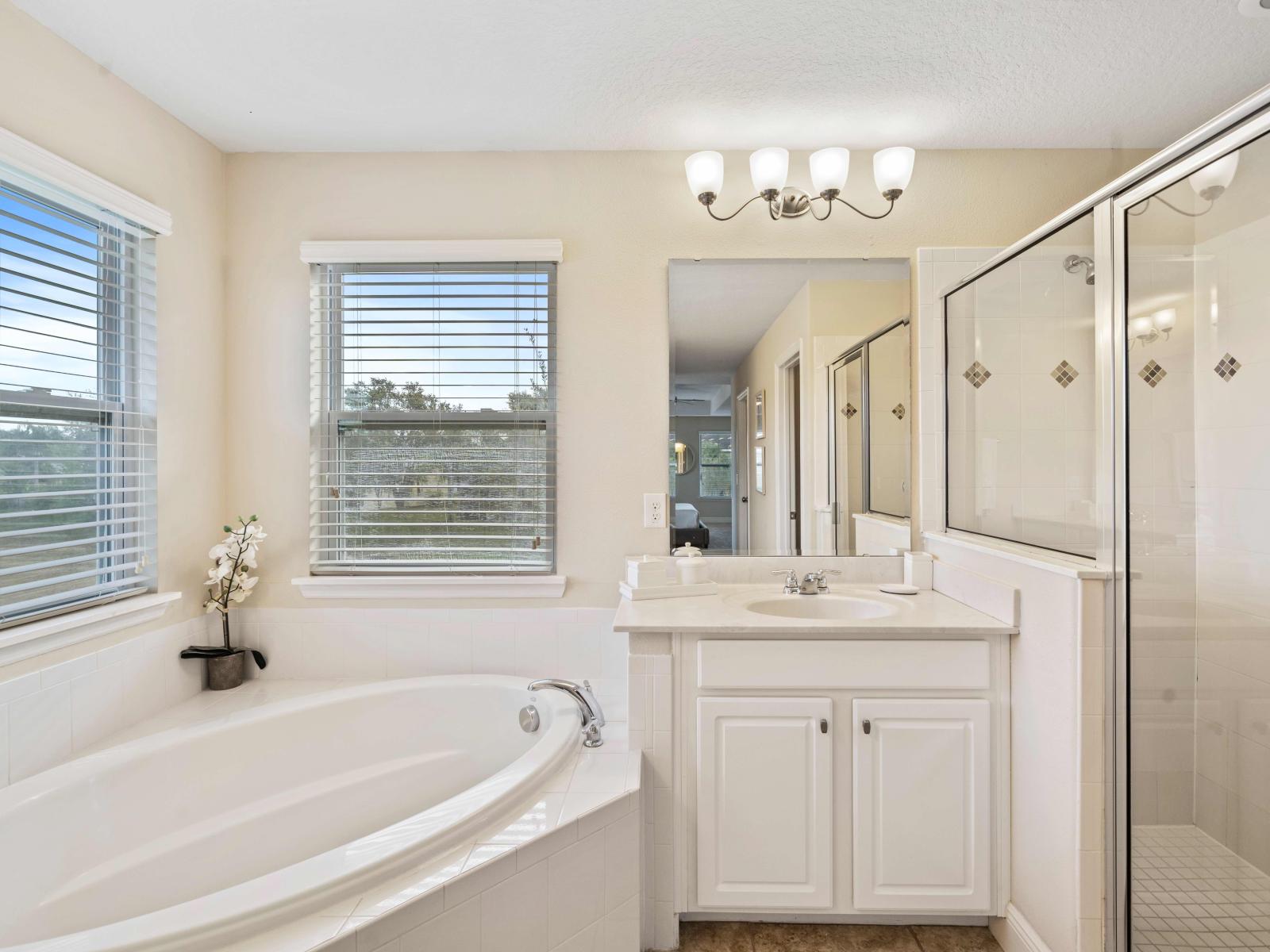 Unwind and relax in our tranquil bedroom retreat of the home in Davenport - Classy vanity with big size wall mirror and wall lamps - Stunning glass cabin shower area - Cozy bathtub - Plenty storage