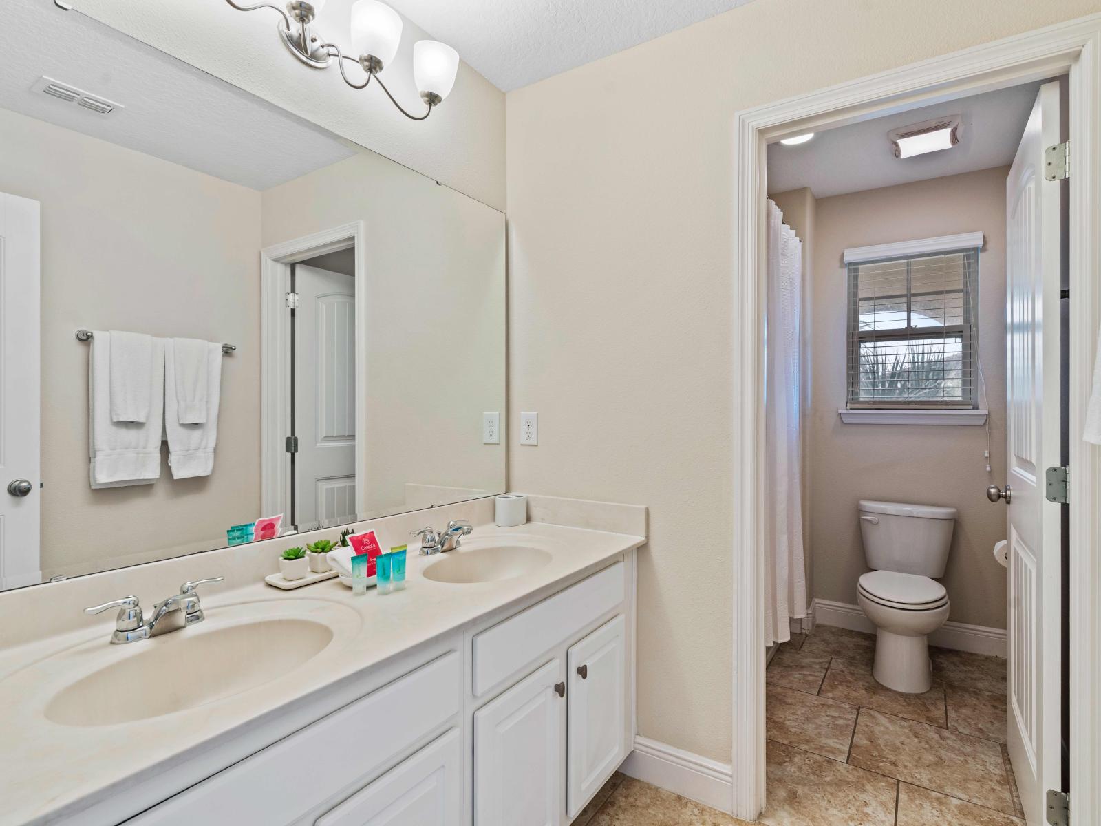 Lavish Bathroom of the home in Davenport - Availability of all bathroom amenities with fresh towels - Neat and cozy toilet seat - Glorious double sink vanity with large wall mirror and wall lamps