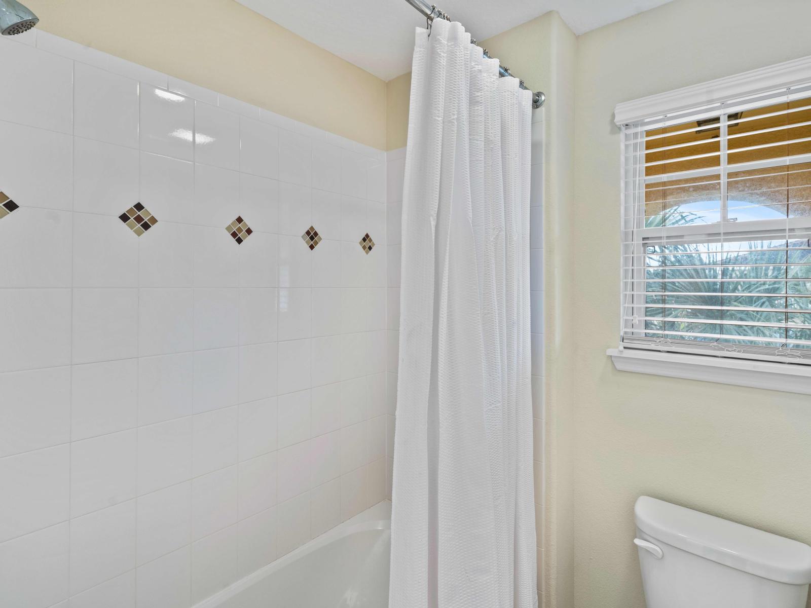 Our bathroom of the home in Davenport exudes tranquility with its soft color palette and natural light. - Plenty storage space ensures a clutter-free environment for your essentials. - Cozy Bathtub and shower combo - Neat and clean toilet seat