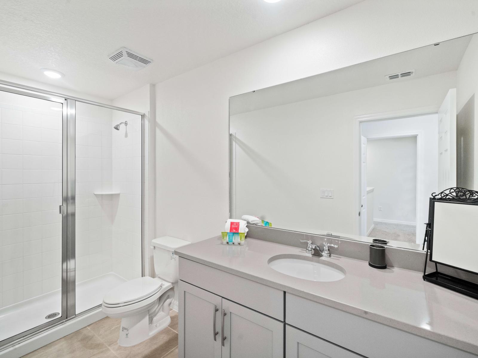 Relaxing Bathroom of the Townhouse in Kissimmee Florida - Chic design featuring a sleek vanity and upscale lighting - Seamless design featuring a glass-enclosed shower for a modern touch